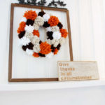 Cozy thoughts happen when you see this DIY Fall pom pom wreath. It's a knock out in stunning Autumn colors!