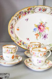 French Cajun dining room décor ideas inspired by Empress Dresden Flowers China pattern. Dining room ideas to including a gray painted china hutch and pink rug.