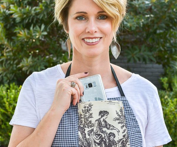The perfect craft apron from fabric scraps, old clothes and linen closet toss outs. An easy pattern idea for how to make an apron from a shirt. This apron even has a cell phone pocket and hammer loop.