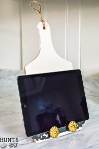 Dollar store decorating hacks for you to get your home decor on a dime! This dollar store DIY turns a wood cutting board into a tablet stand for recipe time in the kitchen.