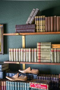 Built in cabinets can be expensive, read all the reasons to use open shelving vs built-in storage for a more stylish and affordable home. Make your study or library room cozy and charming with this moody green paint and faux built-in. #fremchcountrycottage #libraryroom #openshelf #storageideas #DIYcabinet #DIYstorageidea #frenchcountryoffice