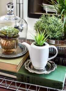 Adding vintage items to your coffee table décor is the perfect way to add age and interest to your living room. WIth these coffee table styling tips you will have your tabletop vignette rocking a vintage vibe in no time! #vintagestyle #coffeetabledecor #plantlady #mixedmetaldecor #vintagesilver #coffeetable