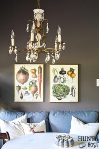This moody boho vintage breakfast room takes advantage of the vibrant color palette popular in 2019 with a vintage chandelier, dark IKEAS sofa, vintage farmhouse prints and tons of texture you are sure to see some boho decorating ideas you can steal. #bohodecor #vintagestyle #breakfastroomdecor #moodycolors #coloroftheyear #painttrends2019 #vintagechandelier