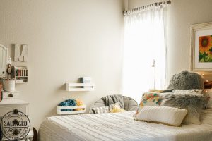 Design a cozy reading corner in your bedroom for a soft and dreamy retreat perfect for getting lost in a good book! Simple touches set the mood for this reading nook! #bookworm #readingnook #readingcorner #bedroomretreat #booknook #cozyreadingcornerforteens #DIYcurtains #bookshelf #cratefurniture