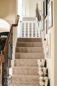 How to build a stylish stairway gate to keep pets or kids out! This easy DIY gate tutorial will look great and blend with your traditional decor. We keep our dog off the carpet with this pet gate. #petgate #stairgate #childproof #DIYpet #cleancarpet #doggate #petgatediy #petgateforstairs