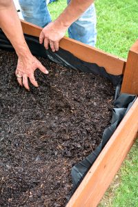 Learn how to spray stain on wood along with tips on how to clean your srpayer when you spray an oil based stain. HINT: it is so much easier than you think! This DIY raised garden bed got a spray stain that will help the wood look good and last longer and it only took minutes to do,. #wagnerspraytech #spraystain #oilbasedstain #paintcleanup #sprayertips #stainedwood #flowergarden #vegetablegarden #raisedbed #landscapedecor #fencestain #diyfencestain