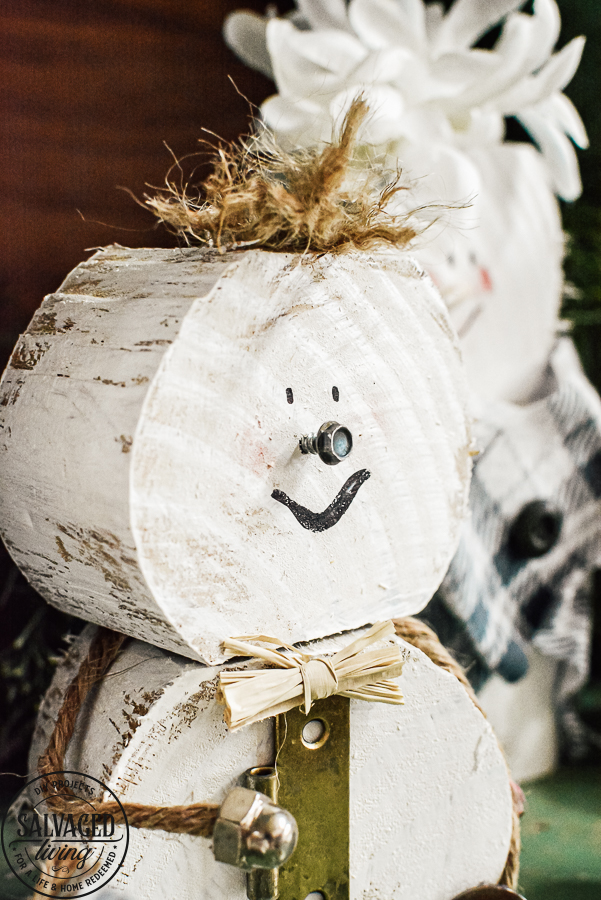 Learn how to make a cheap and easy DIY scrap wood snowmen family. The perfect Christmas decoration or gift idea for a family. This easy snowman craft lets you personalize each snowman face and outfit with junk art from your house! #holidaydecor #handandeChristmas ##snowmancrafts #woodensnowmen #farmhouseChristmas