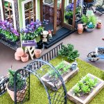 Tour a miniature vintage garden shop dollhouse for great ideas for your own dollhouse decor. See how to make a cozy home, lush garden and outdoor miniature yard! COmplete with garden gnomes, miniature potted plants and sitting areas. #dollhouse #miniatures #DIYdollhouse #vintagegarden #tinydecor