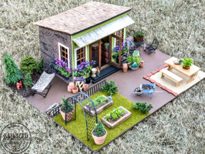 Tour a miniature vintage garden shop dollhouse for great ideas for your own dollhouse decor. See how to make a cozy home, lush garden and outdoor miniature yard! COmplete with garden gnomes, miniature potted plants and sitting areas. #dollhouse #miniatures #DIYdollhouse #vintagegarden #tinydecor