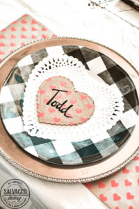 Create a romantic table for Valentine's Day on a tight budget with tons of dollar store crafts mixed with vintage items to bring together a romantic picnic...inside! Bringing the outdoors is always a stylish budget friendly option for holiday decorating! #valentinesdaydecorations #valentinesdaycrafts ##valentinesdaydollarstore #romantictable #farmhousevalentinesday