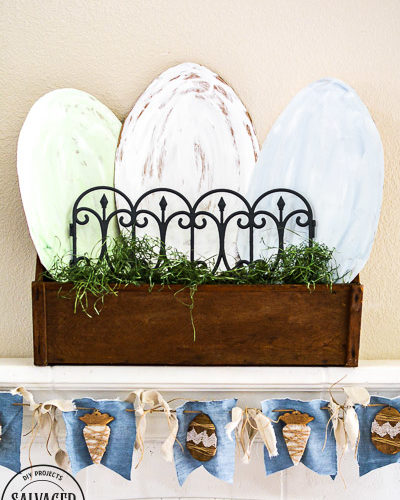 Decorate your mantle for Easter with this budget Easter mantle decorating idea from cardboard! Seriously the best budget decorating hack there is , so easy and you can paint it any color or style. Also tips to make an Easter banner from dollar store items and things you have on hand at home already. #budgetdecor #eastermantle #easterdecoratingideas #dollarstorecraft #dollartreedecor