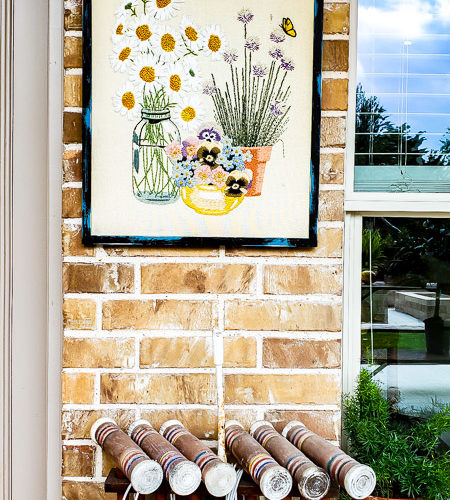 Learn how to hang pictures on brick wall easily with this step by step tutorial. Haning pictures on brick is easy with the right tools and can make your outdoor living space feel like a cozy room in your home. #howtotip #decoratinghack #patiodecoridea