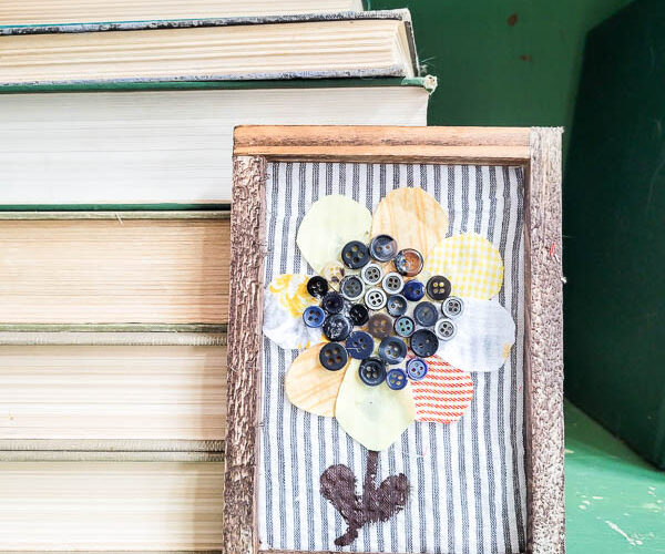 finished sunflower art in frame on table with books