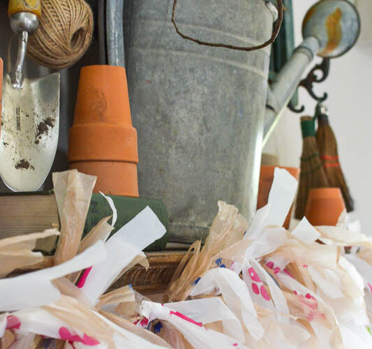 Learn how to make adorable garland from plastic grocery bags you get at the grocery store. his budget friendly DIY idea is perfect for decorating your mantel. #garland #plasticbagcraft #upcycle #budgetdecorideas