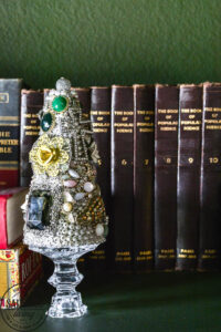 vintage jewelry tree next to books