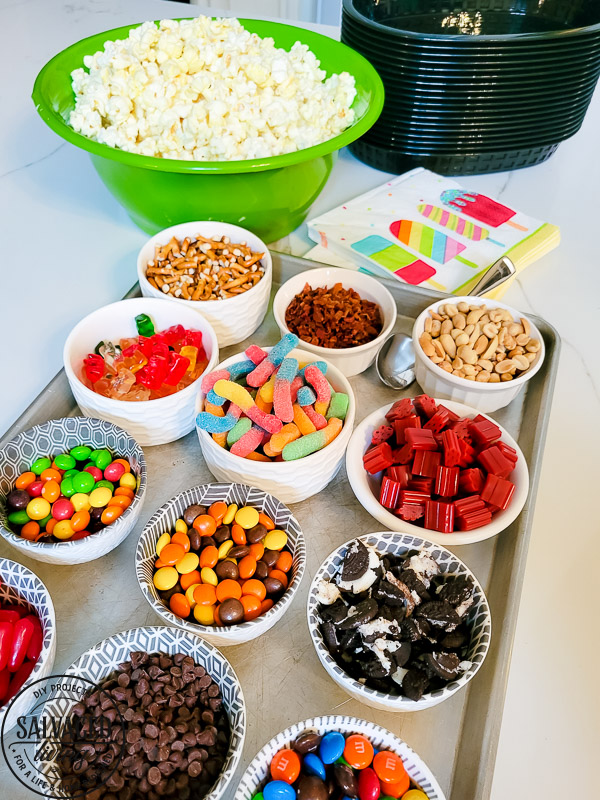 Get a free print out shopping list of the most amazing toppings for a gourmet popcorn bar. A popcorn bar is perfect for entertaining a crowd, it covers all the bases - salty, sweet, savory and sour. I have a list of the perfect popcorn bar ideas for you here! #popcron #crowdpleaser