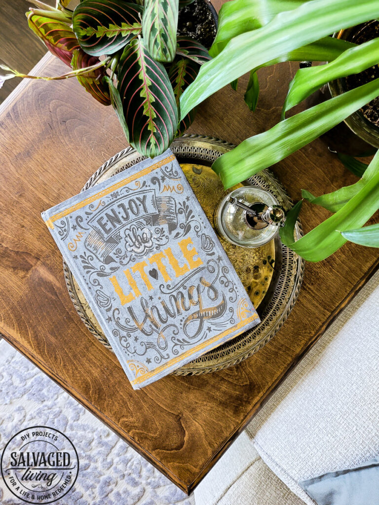 stenciled old dictionary book on table with plant