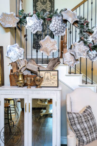 This simple DIY snowflake garland from dollar store felt pieces and Rust-Oleum Imagine spray paint is the perfect winter wonderland addition. Bring a flurry of snow to your holiday home decor with a papercraft for any decor style. The perfect DIY staircase decorating idea for your holiday banister! #rustoleum #rustoleumimagine #snowflake #winterwonderland #holidaydecor #holidaydecorating #christmasdecor #sponsored #staircasedecor