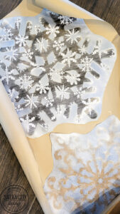 This simple DIY snowflake garland from dollar store felt pieces and Rust-Oleum Imagine spray paint is the perfect winter wonderland addition. Bring a flurry of snow to your holiday home decor with a papercraft for any decor style. #rustoleum #rustoleumimagine #snowflake #winterwonderland #holidaydecor #holidaydecorating #christmasdecor #sponsored