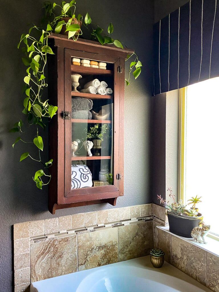 a thrifted cabinet found at a garages sale is perfect for a cozy bathroom upgrade, come see how I decorated this garage sale cabinet for function and style. #bathroomdecor #vintagebathroomstyle #cozybathroom