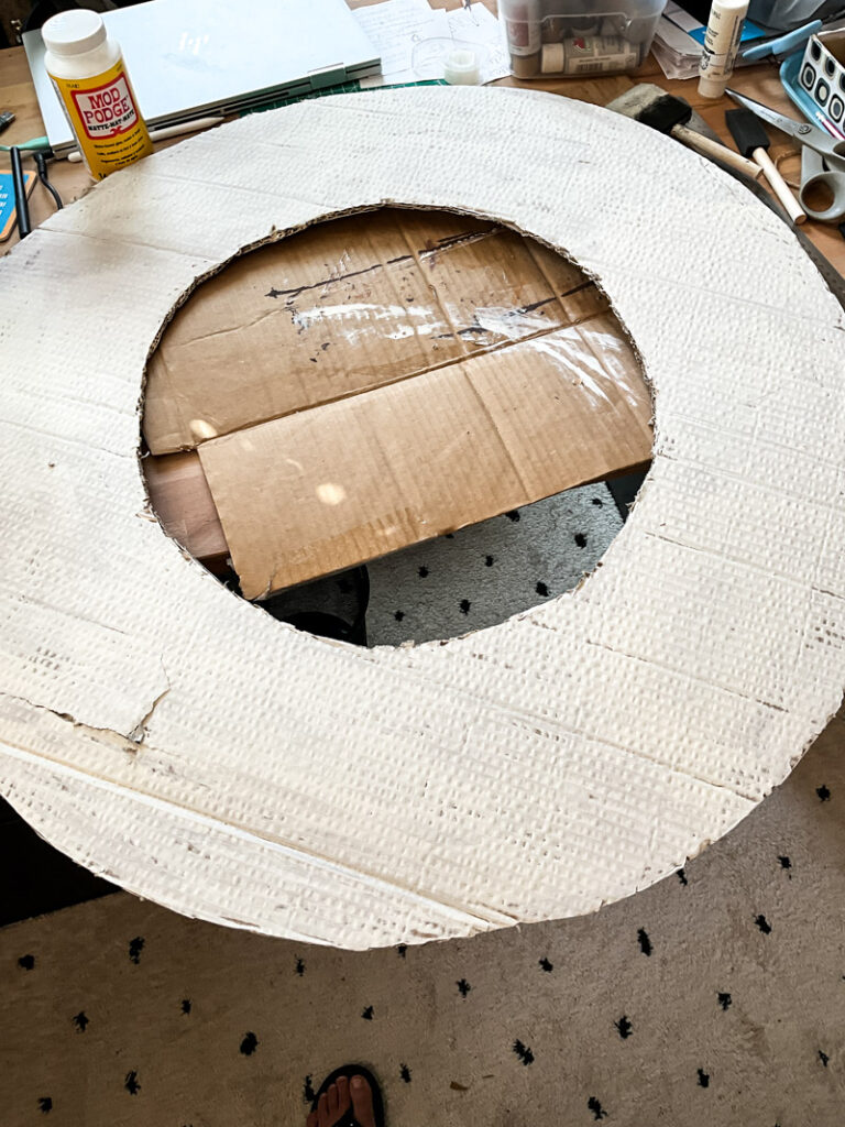 Make a life-size life preserver for vintage summer decorating. This large cardboard project will add a vintage vibe to your beach house, summer vignette or nautical decor motif. So easy and super budget-friendly. #budgetsummerdecor #beachtheme #vintagestylesummer