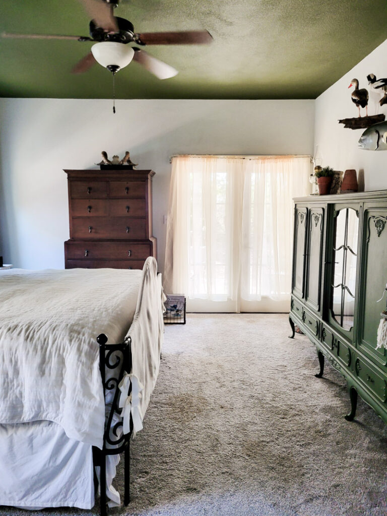 Master bedroom redo. Vintage paint color palette and budget curtain hack, get the look for less from Ballard Design. Buffalo check curtains make big impact for cheap. #greenbedroom #vintagebedroom #taxidermy #affordablecurtains