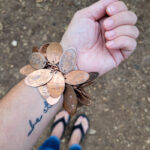 How to make a pressed penny bracelet. This DIY charm bracelet is made from inexpensive collectible souvenirs. FInd the best vacation memory in these pressed penny pieces! Then take them home amd add them to your memory keeping charm bracelet, copper is so beautiful and perfect for reliving favorite vacation spots all while looking uniquely stylish! This is an easy DIY jewelry project that has a ton of meaning. #charmbraceletDIY #pressedpennyidea #pennydisplay #souvenircollection #travelmemory